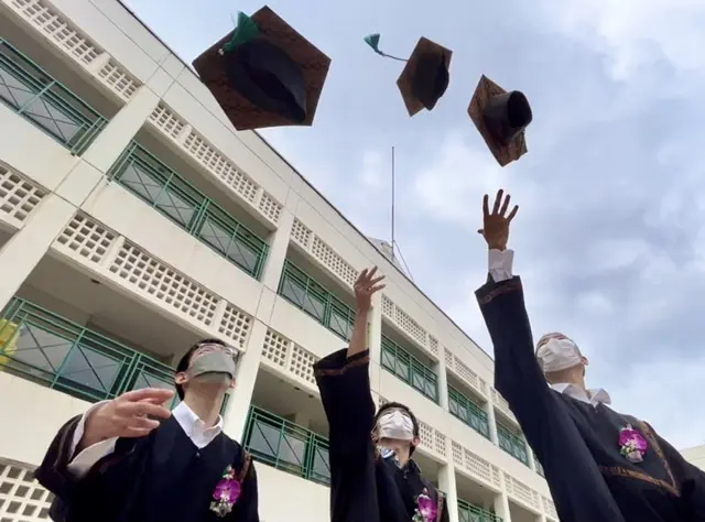 アカデミックガウンで帽子を投げる