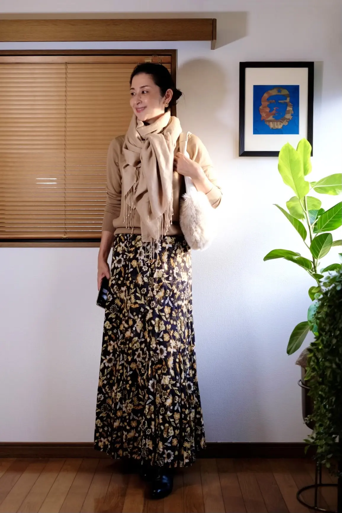 ユニクロのベージュニット、黒ベースの小花柄ロングスカート、黒のショートブーツ、白のファーバッグ、ベージュの薄手ストール