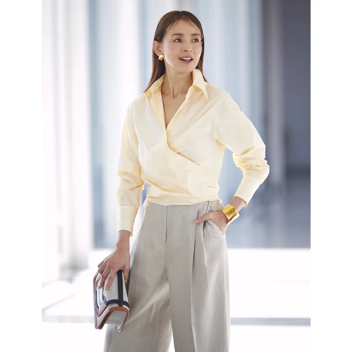ペールイエローのカシュクールシャツにライトグレーパンツを合わせたコーデ　モデル・SHIHO