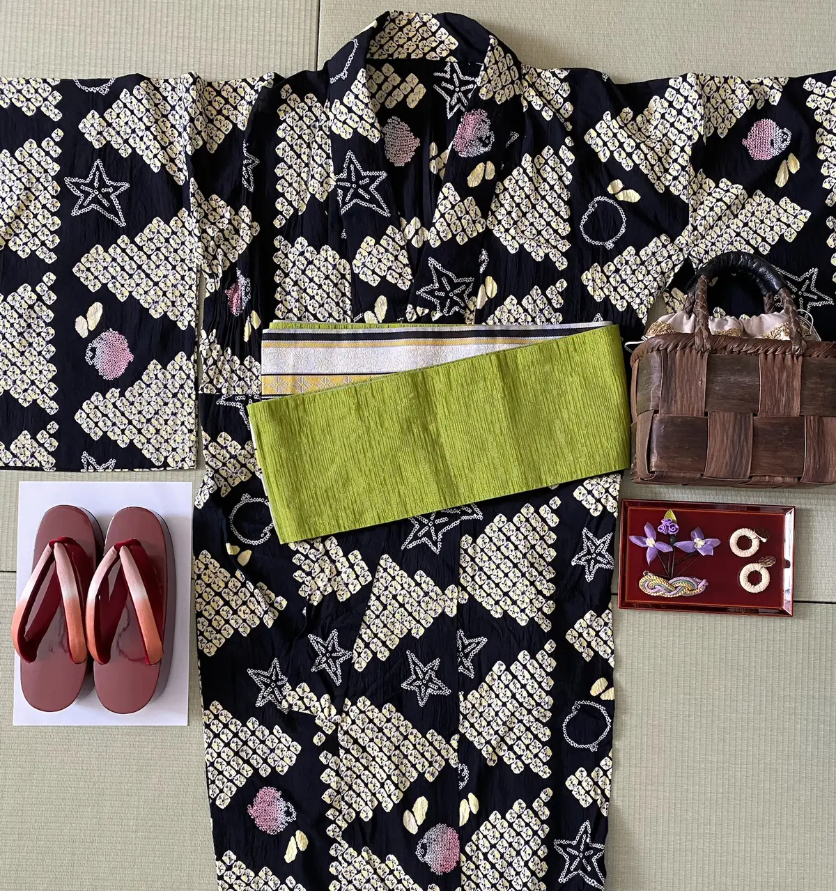 浴衣コーディネート一式の床置き画像。有松絞り浴衣、かごやのカゴバッグ、リバーシブルの帯、朱塗りの下駄、顔まわり小物