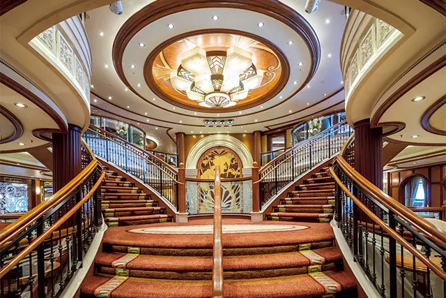 階段の踊り場にしつらえられた寄木細工の壁アートが目をひく、壮麗なグランド・ロビー。初代クイーン・エリザベスをモデルにしたアートで、故・英国女王エリザベス2世の甥にあたるデイビッド・リンリー氏作