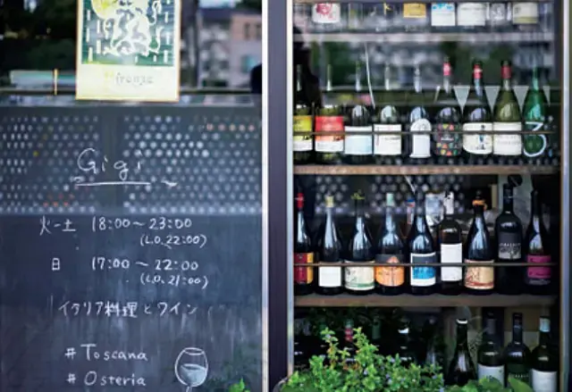 ガラス窓にずらりと並ぶ空きボトルがファサードに。