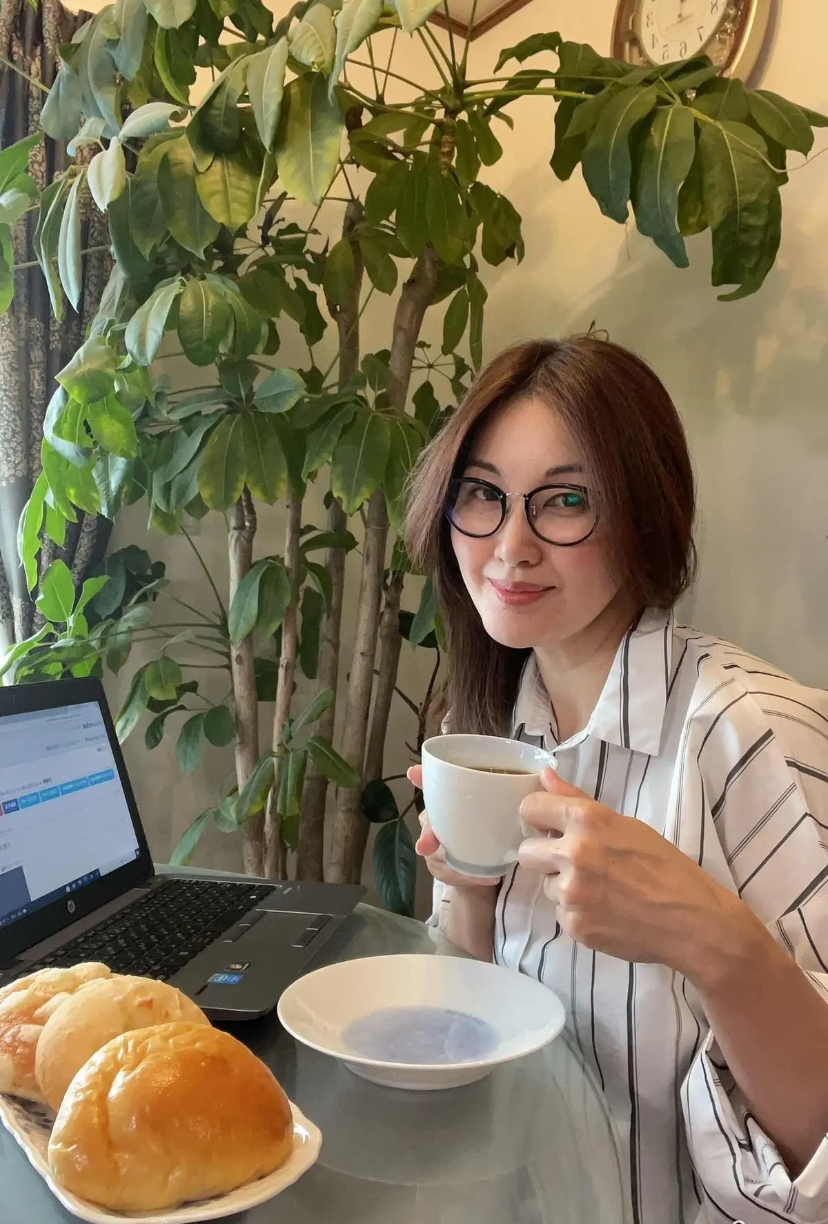 パソコン前　コーヒーカップを持つ女性