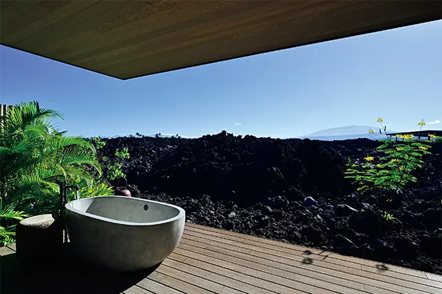 ASAYAスパのトリー トメントルーム。テラ スからすぐに壮大な溶 岩大地が続き、遠くに フアラライ山を望む絶 景。センス・オブ・プ レイスを実感する。施 術は、屋内のベッドで