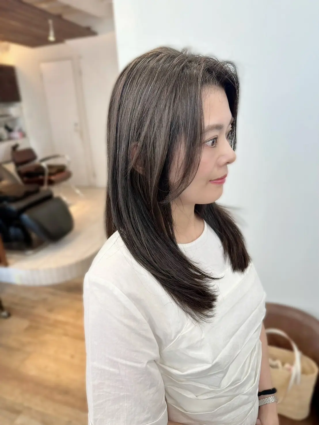 酸性ストレートとベージュカラーで仕上げた艶やかなロングヘアの横顔