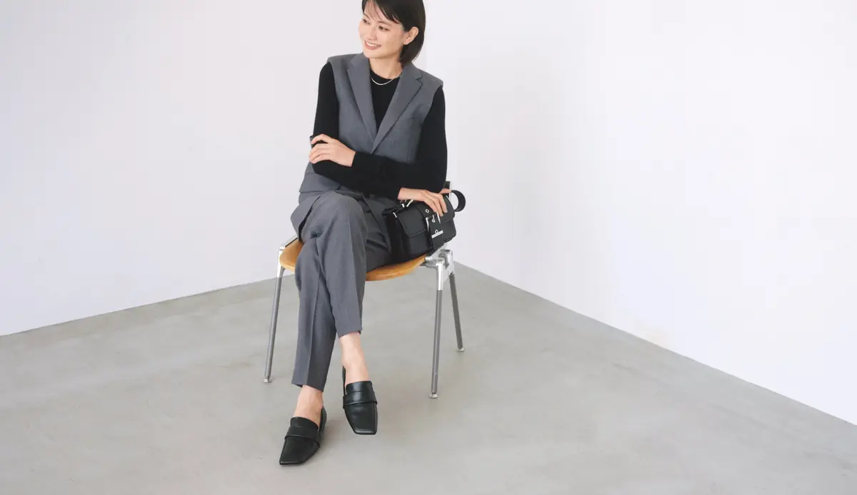 黒トップスにグレーのジレとパンツのセットアップを合わせたコーディネート　モデル・渡辺佳子