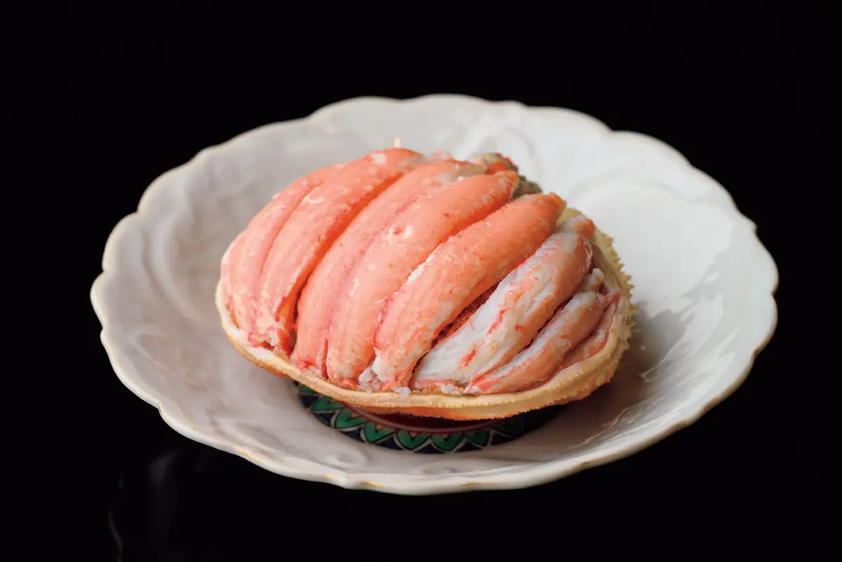 国内旅行　金沢　和食　『竹千代』　11月初旬〜12 月末限定の香箱ガニ。内子外子 とみそとともに。細い脚は押し つぶして身を出す方法が多いが、 この店では一本一本抜き身する。 お任せコースのみ。煮物のほか お造り、椀物、胡麻豆腐、季節 の土鍋ごはんなど10品ほどで￥ 13,200（香箱ガニは別料金）