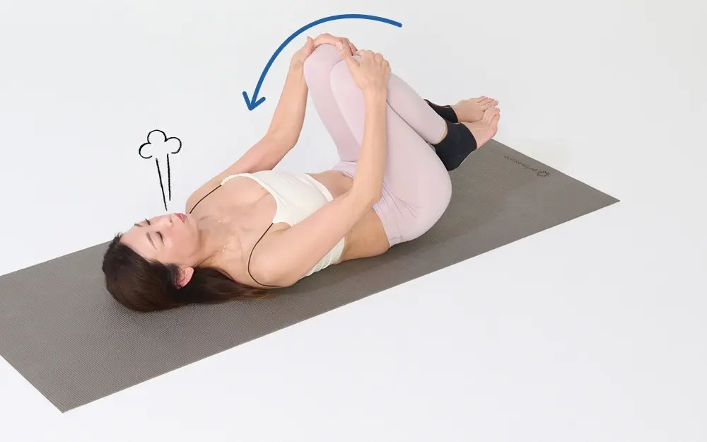 OurAge×Webエクラ　あお向けになって両手で両膝を抱えます。