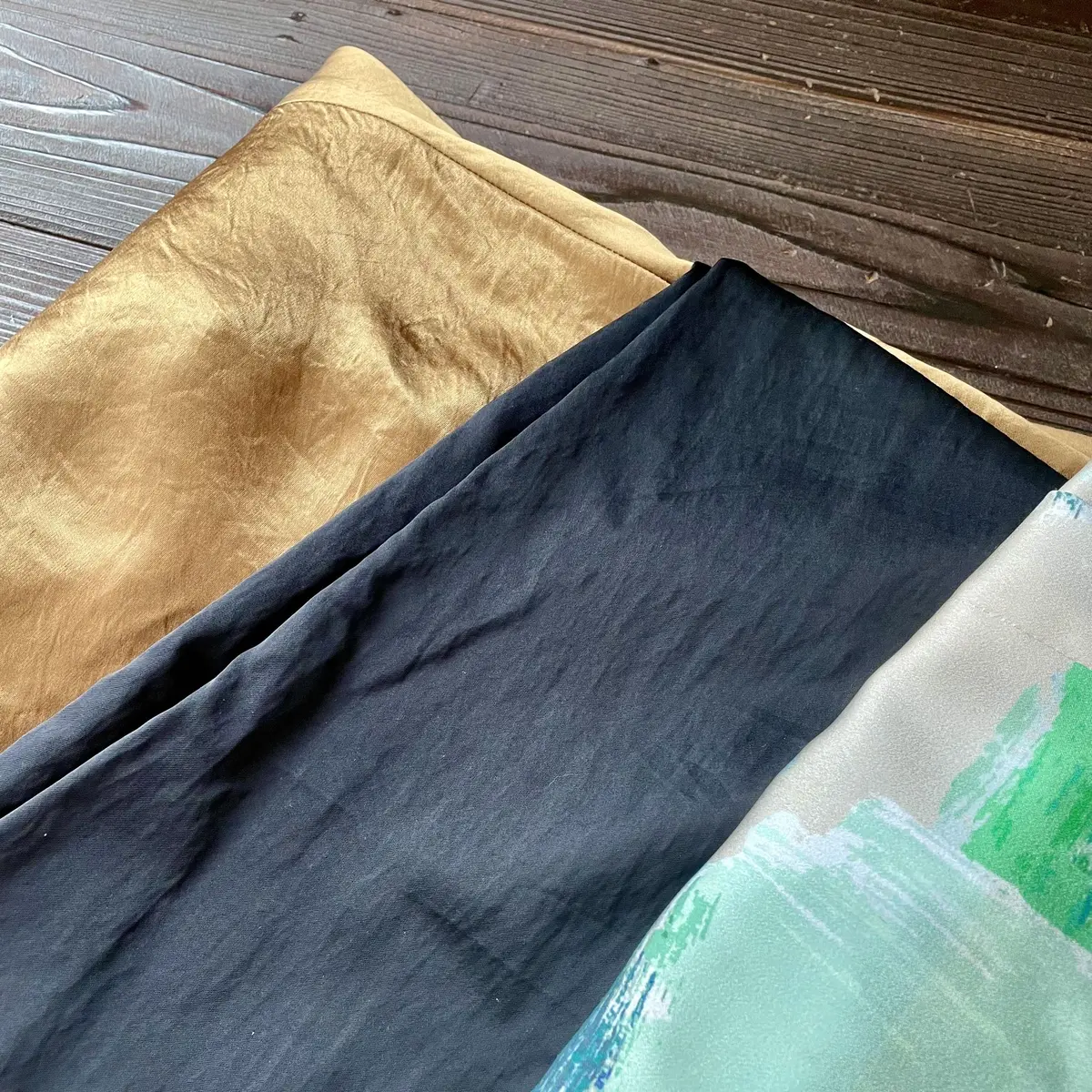 ゴールドスカートの艶あり生地、ブラックパンツの艶あり生地、柄パンツの艶あり生地、