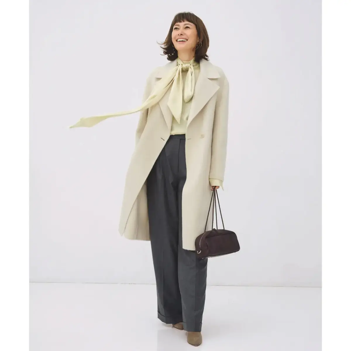 オフ白のコートをはおり、寒さが厳しくなる年の瀬も軽やかに過ごす！