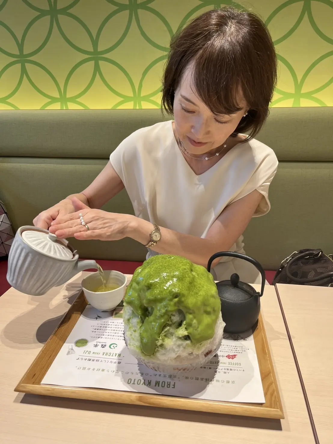 抹茶のかき氷と、玉露を湯呑に注ぐ女性