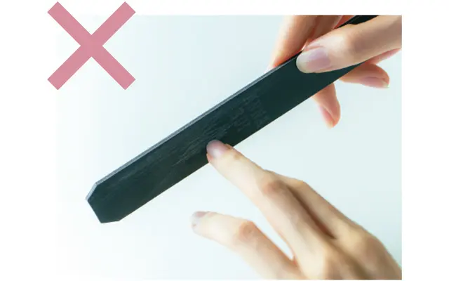 やすりを宙に浮かせ、爪を当てて削るのはご法度。安定性が悪く、ぶれて、一直線に動かせないため、二枚爪の原因に。