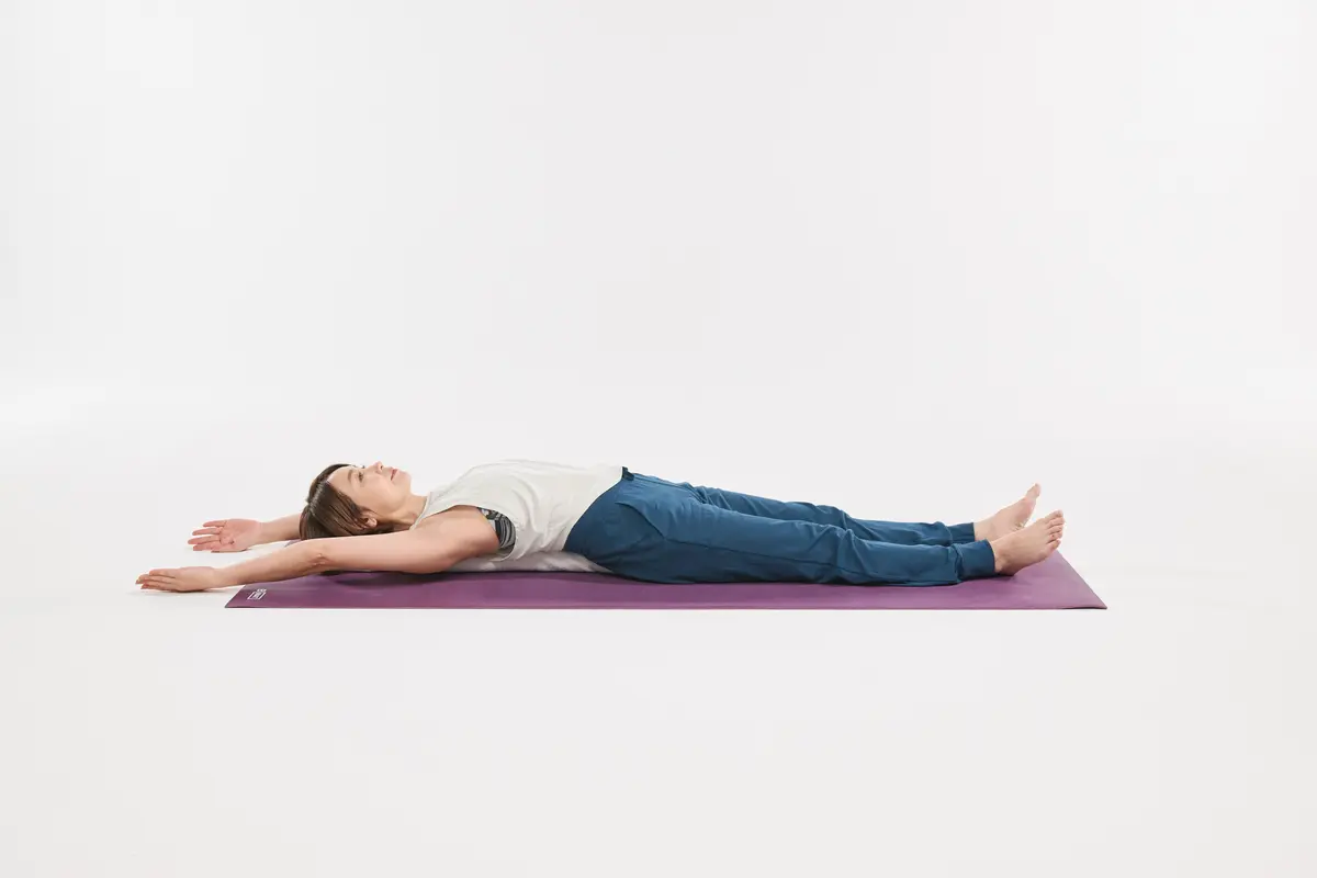  仰向けになり、ストレッチポールや、丸めたバスタオルに頭から背中までをのせ、両腕を上に伸ばす