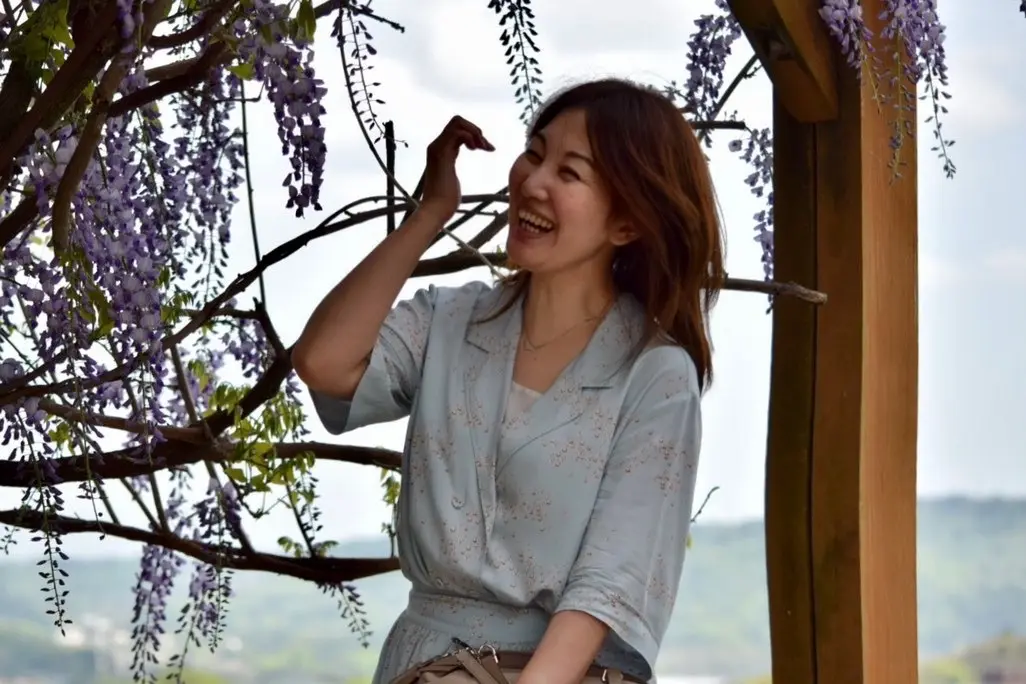 藤棚と笑う女性