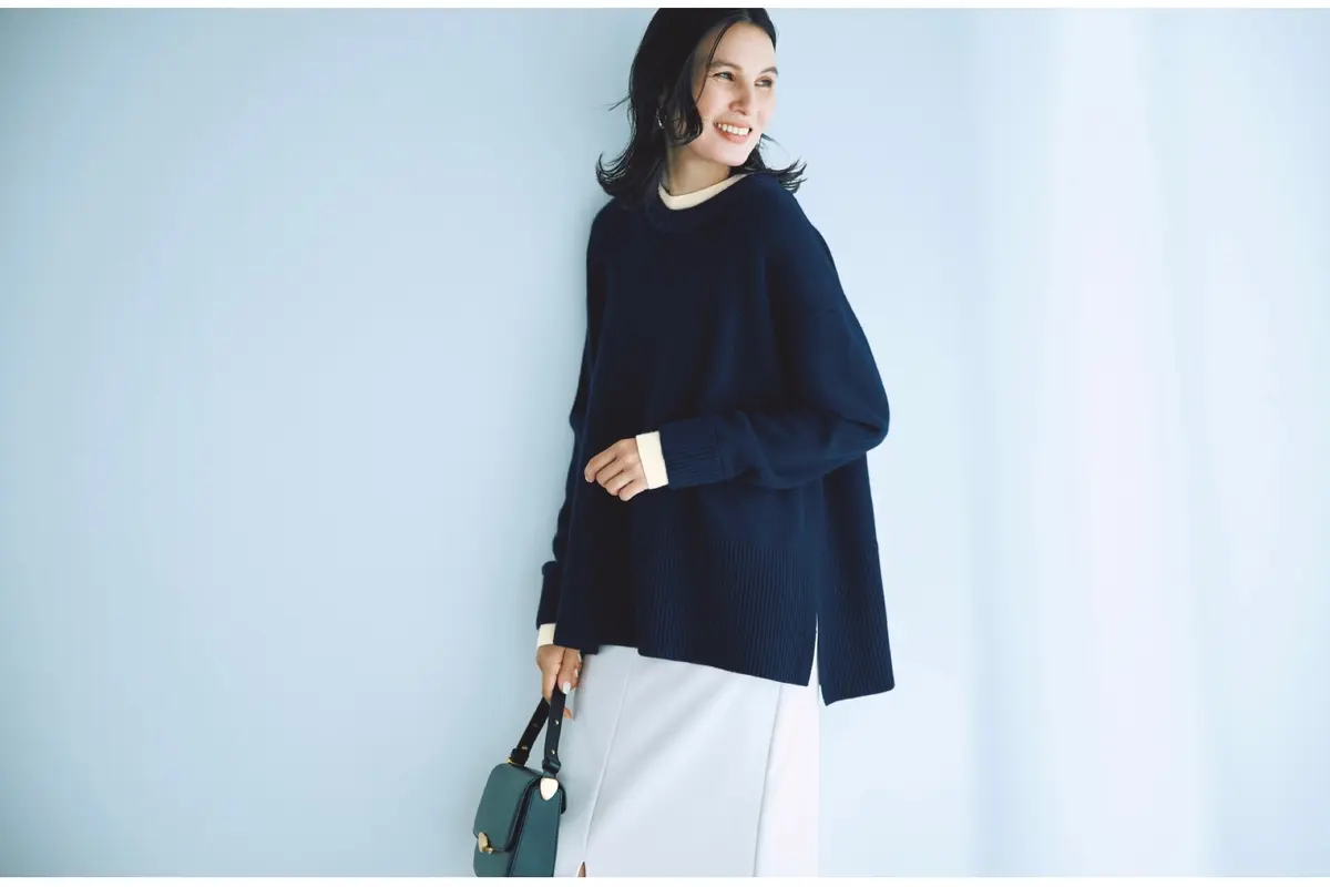 ネイビーニットの首元と袖口から白ニットがのぞいたような重ね着風デザインニットに、白タイトスカートを合わせたコーディネート　モデル・田沢美亜　