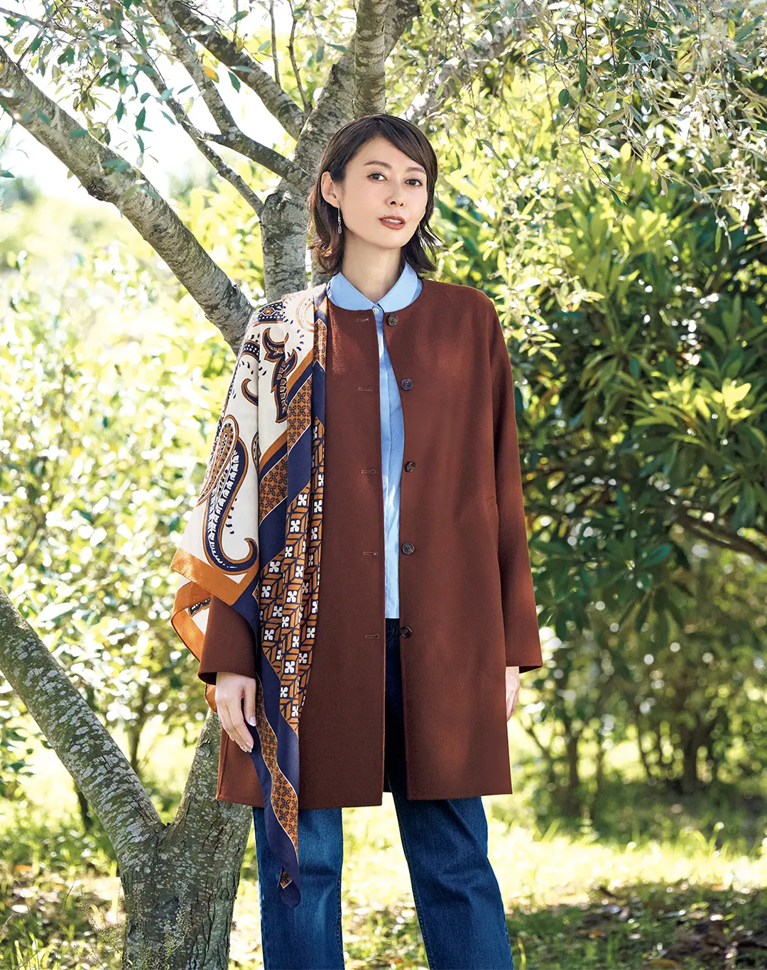 着る人の魅力を引き出す、ノーカラーのリバーコート。ブラウンが秋の日射しに映えて