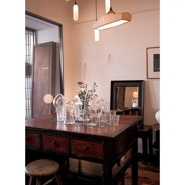 中国・山西省の100年近く前のデスクと、谷口嘉よしみ作のガラスの花器やグラス