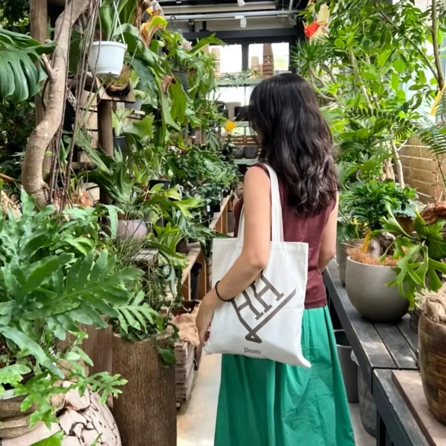 ブラウンのノースリーブニット、グリーンのロングスカート、エクラ特別付録のトートバッグ