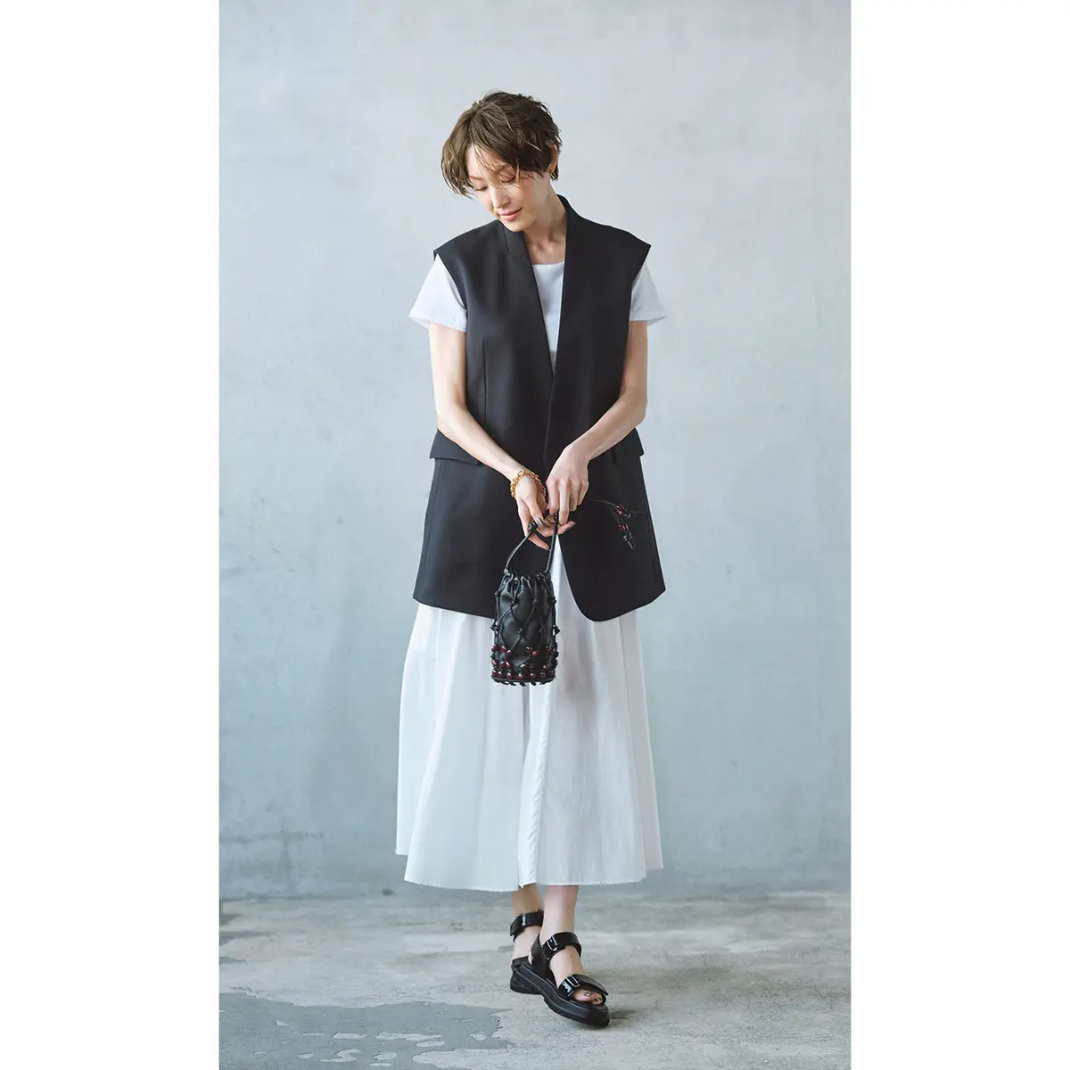 白Tシャツと白スカートに黒ジレを羽織ったコーデ　モデル・LIZA