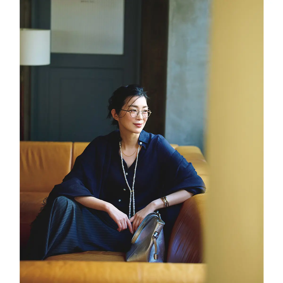 ネイビーのリネンシャツにパールのロングネックレスを合わせたスタイル　モデル・ゆうき