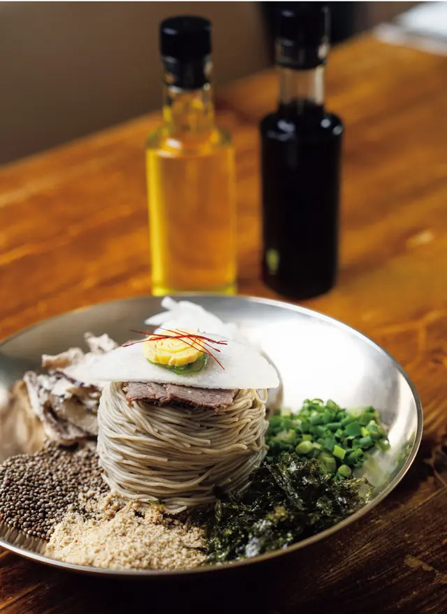 ❷「コルトン冷麵」W18,000。きのこ、大根、えごま、のりなどを混ぜて供すあえ麵。生えごま油としょうゆを回しかけて　