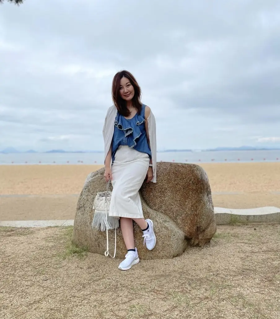 後ろ海　岩の上に座る女性