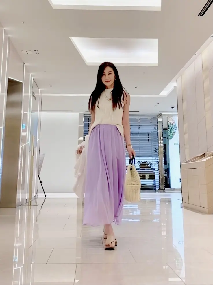 ジャケットを脱ぐと白のノースリーブニット