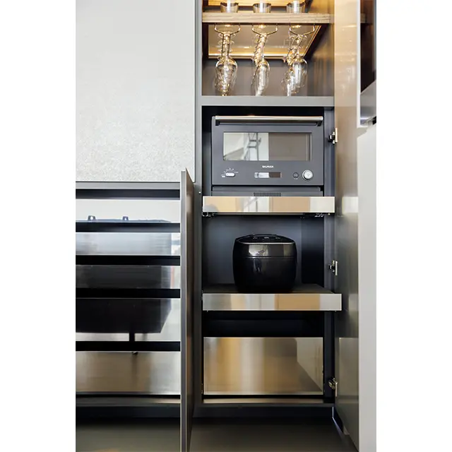 キッ チン家電はバックキャビネットのスライド式の棚の上に。引き出しはステンレスで統一。