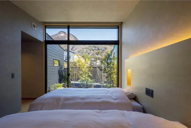 天井高が3m、本棚や机があり長期滞在に自分の好きな空間で過ごせる。シンプルなキッチンもある