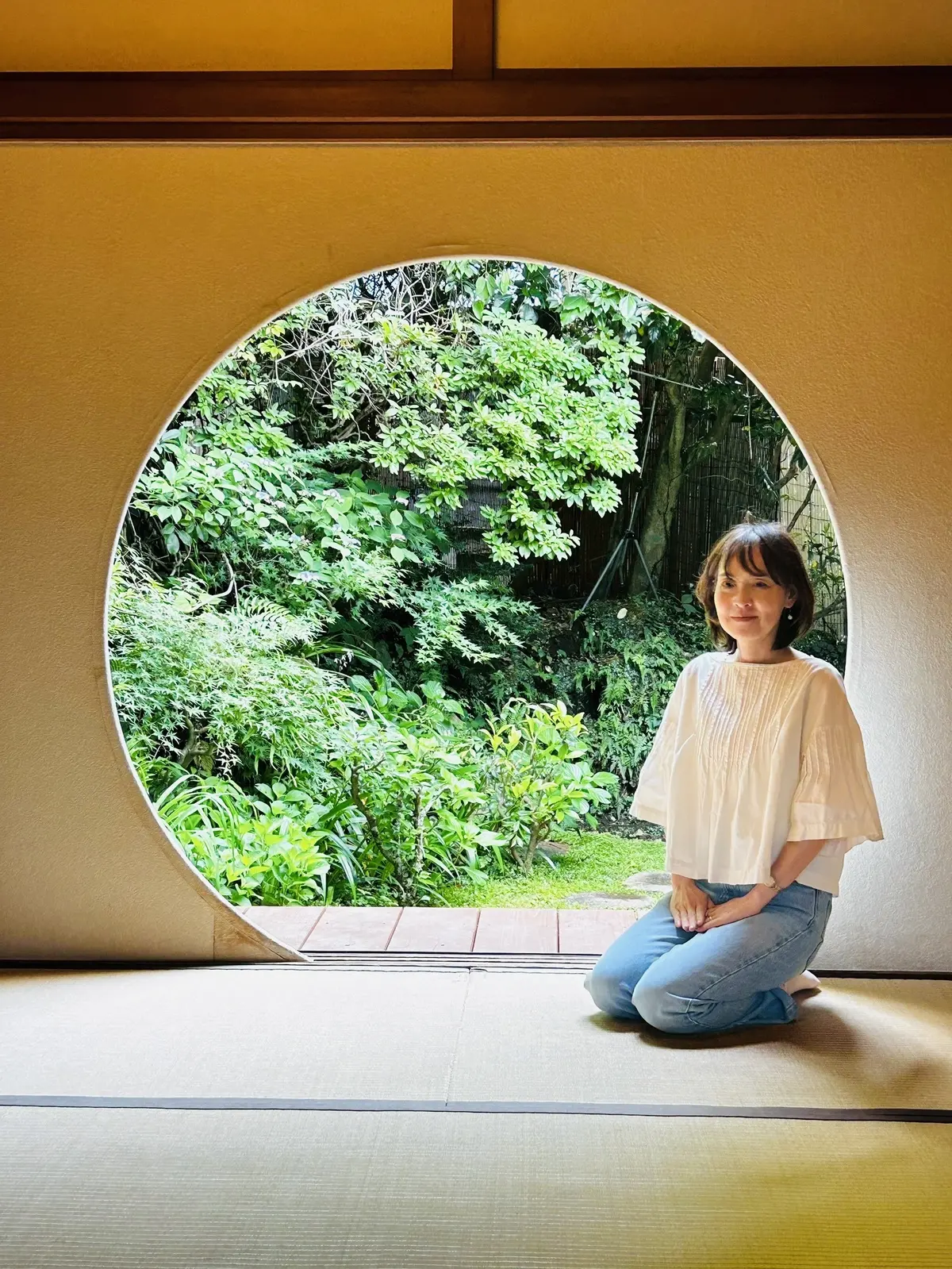 天心庵の和室で天窓をバックに写真を撮る女性