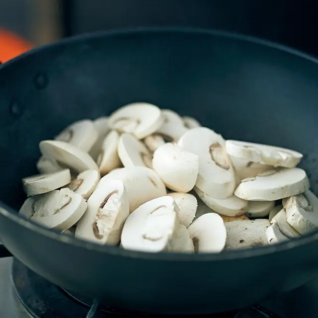 炒めた魚の上にマッシュルー ムをのせて蒸し焼きに