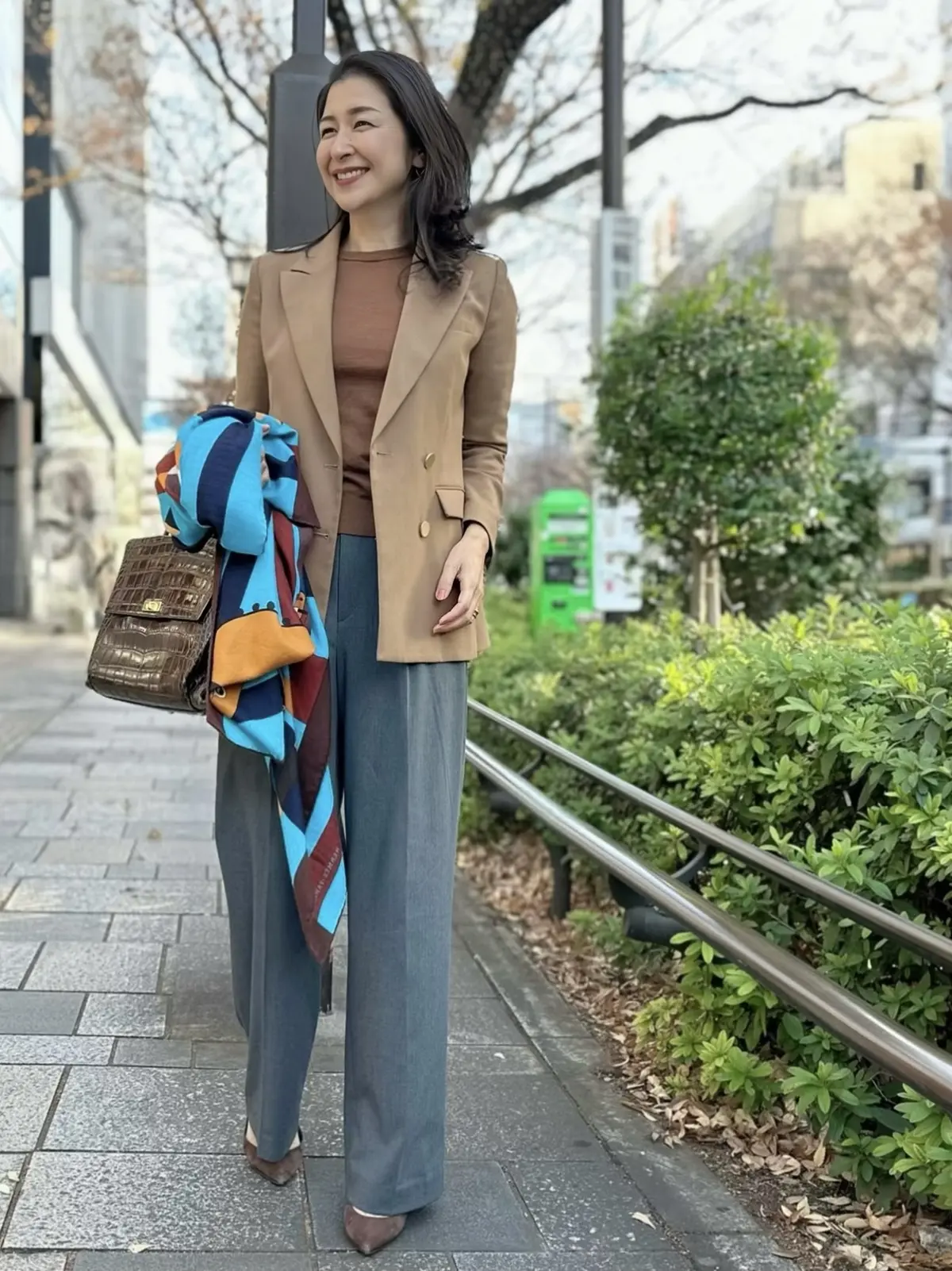 ユニクログレーパンツ、ベージュニット、ベージュジャケット、ブルー系ストール、ブラウンバッグ、ブラウンパンプス