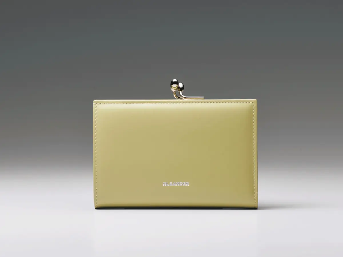 指先で開閉ができるがま口タイプのコインポケットは、 外側に設置してあり使いやすい。内側もスナップボタン でスムーズにアクセス。札入れ1、小銭入れ1、カード挿 し8、ポケット2。二つ折りウォレット（8.5×12.5×2.5） ￥148,500／ジルサンダージャパン（ジル サンダー）