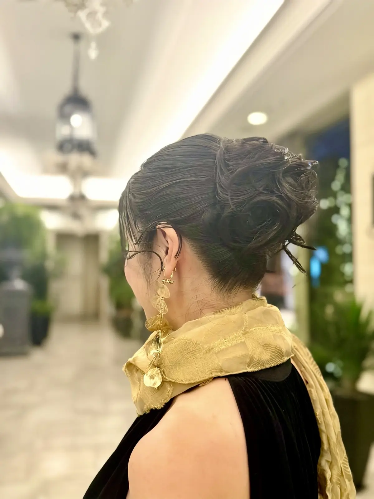 アラフィフパーティーコーデ　アップヘアアレンジ　ゴールド色のストール　ゴールドのイヤリング　50代パーティーコーデ