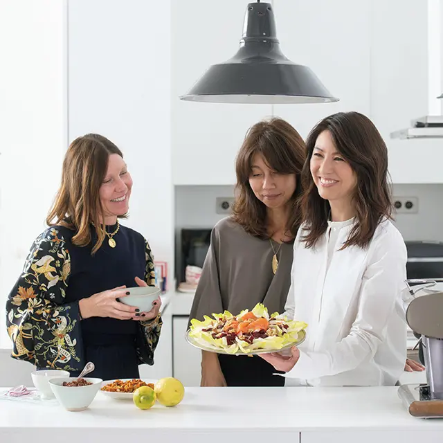 ゲストも一緒にキッチンに 立って準備を。この日は、 友人たちとサラダの盛りつ けを完成。オープンキッチ ンだから、支度をしながら テーブルまわりにいるゲス トとの会話を楽しんで