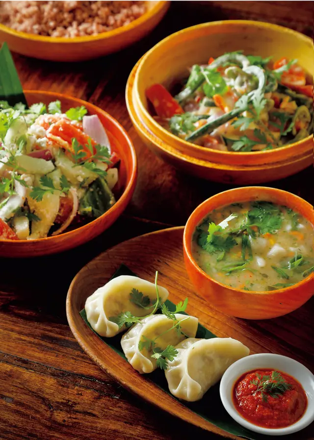 ブータン料理のコースから。この日の前菜は、卵を落とした川海苔とキャベツのスープ、ブータン風餃子「モモ」。主菜は、牛ひき肉と唐辛子のあえ物、唐辛子とチーズのカレーなどを赤米と一緒に