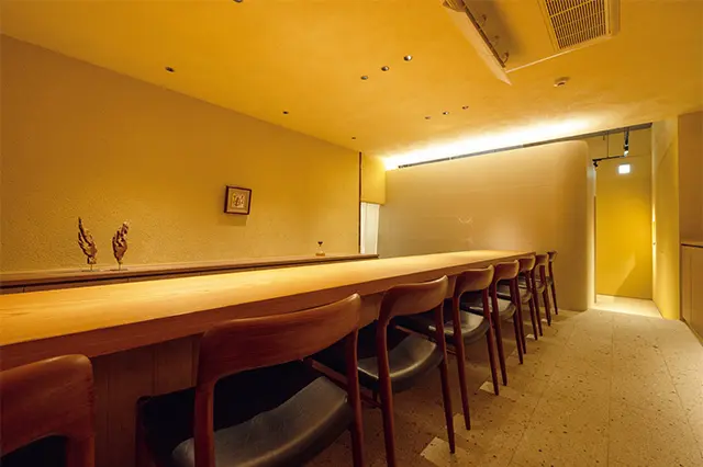 樹齢300年のケヤキを使ったカウン ターも見事。照明を落とし、ビルの1階 とは思えない非日常空間