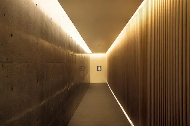 玄関ののれんをくぐると、別世界へと誘いざなわれるような通路が続く、コンクリートを用いた安藤建築