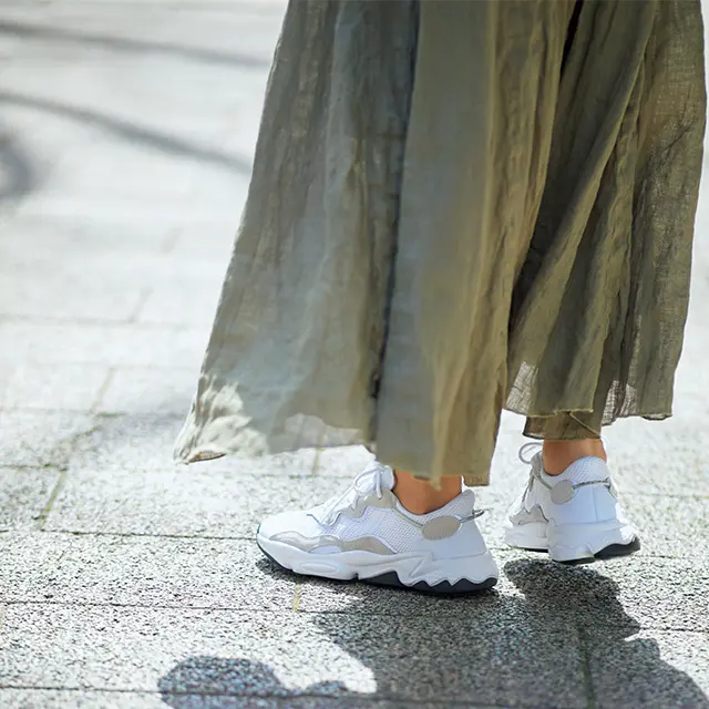 カーキスカートとスニーカーにあしらった淡いグレージュが好相性。