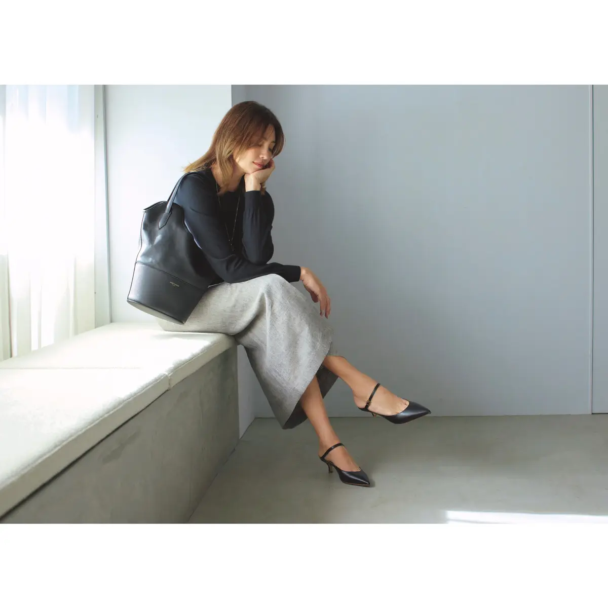 黒ニットとグレータイトスカートに黒ミュールを合わせたコーデ　モデル・RINA