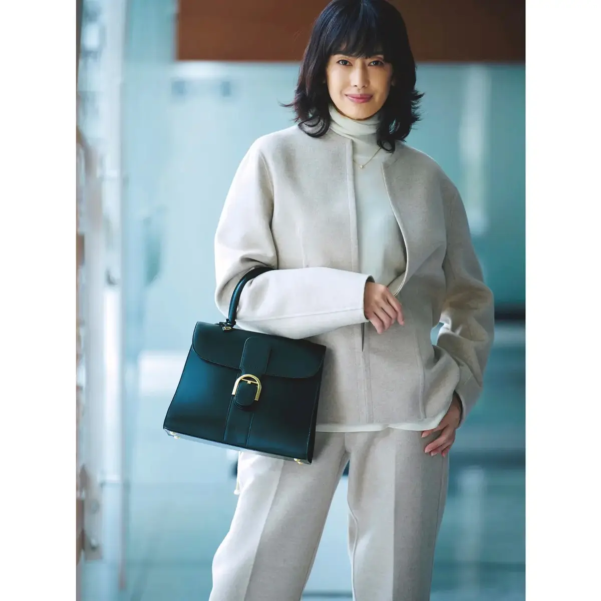ベージュ×白を端正な黒バッグで引き締め、通勤コーデをクラスアップ。気温15℃