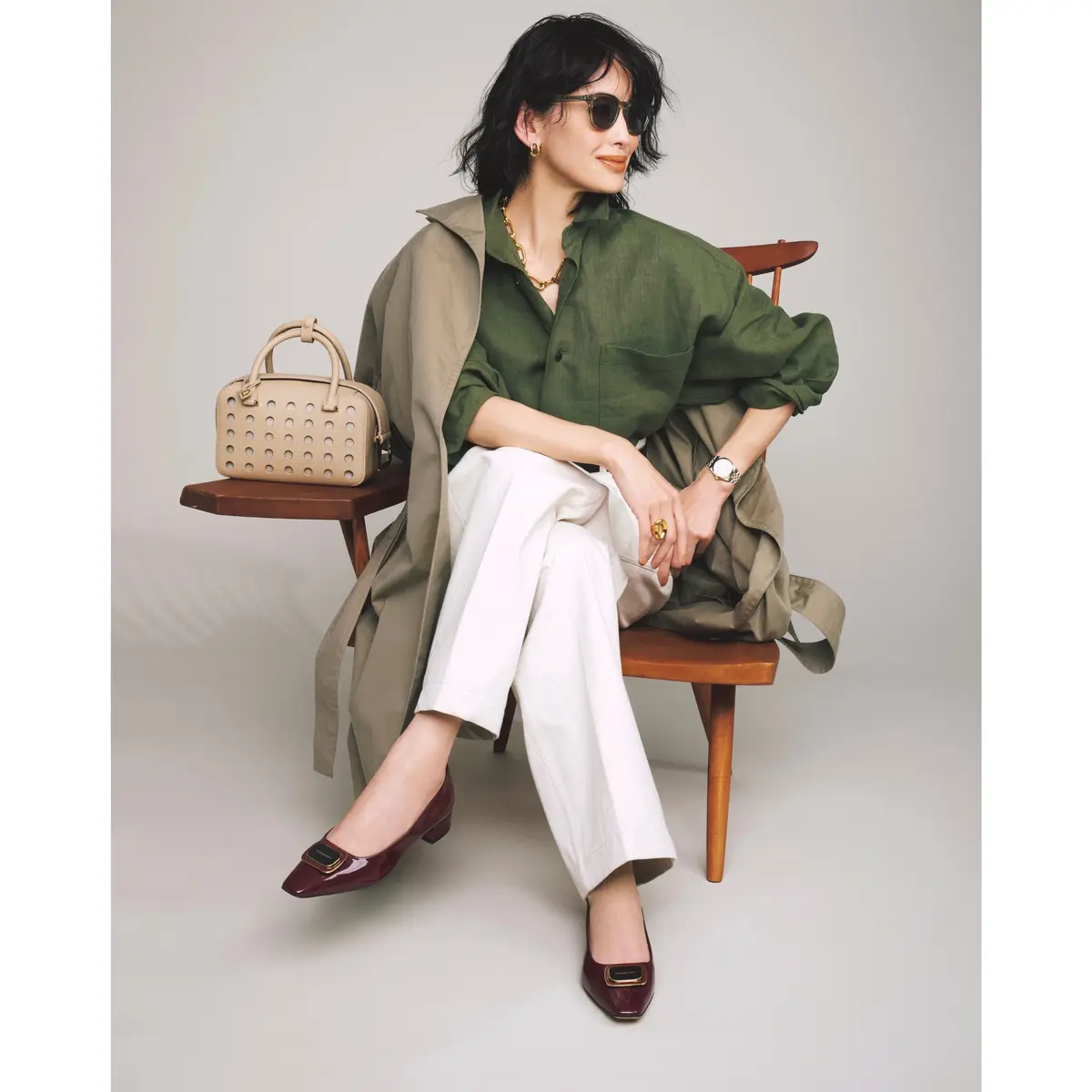 カーキシャツと白パンツの組み合わせにベージュトレンチコートをはおったコーディネート　モデル・高橋里奈