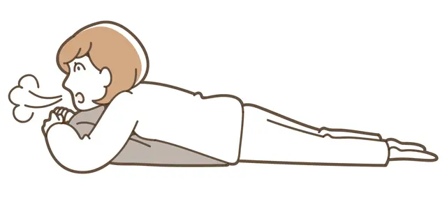 枕を胸の下に入れ、両足を肩幅くらいに開いて下半身をゆるめ、さらに3分間深呼吸