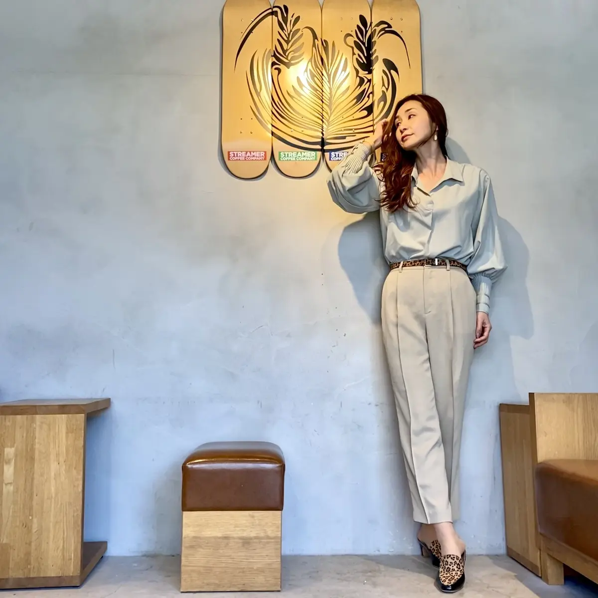 淡いグリーンのブラウスとベージュのパンツにレオパ柄のベルトと靴