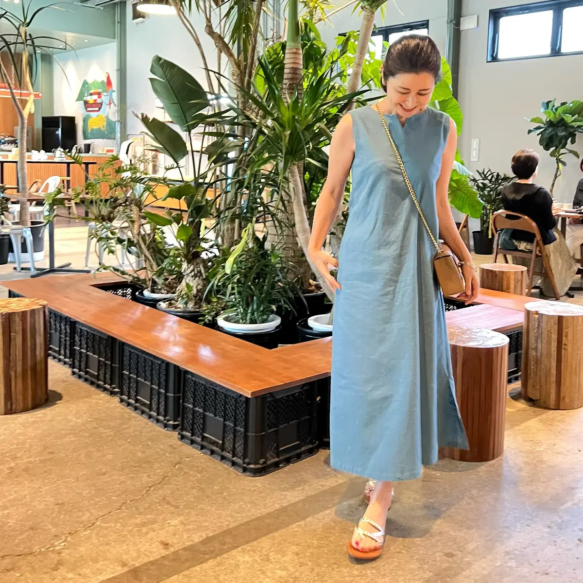 ブルーのワンピース、キャメルのポシェット、ゴールドのフラットサンダル