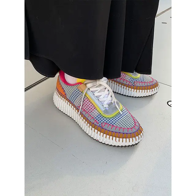 黒いパンツからちらりとのぞくスニーカーのカラフルさが目を引いた、展示会回り中の編集長K藤。