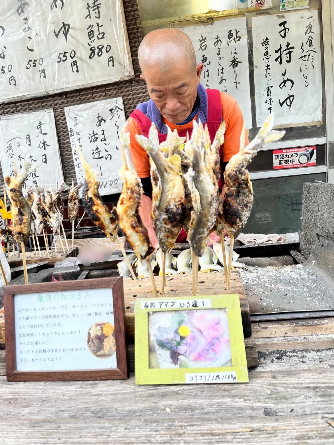 炭火焼きのいい香り。向かって左側のボードに「亀清のおつまみはおっちゃん自慢の手作りおやつです」って!