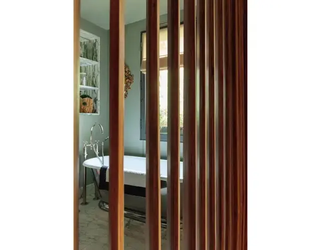 ブラインド式の、バスルームとの仕切り板を回転させ、オープンにしたところ。バスタブは表面をシルバーでペイント。