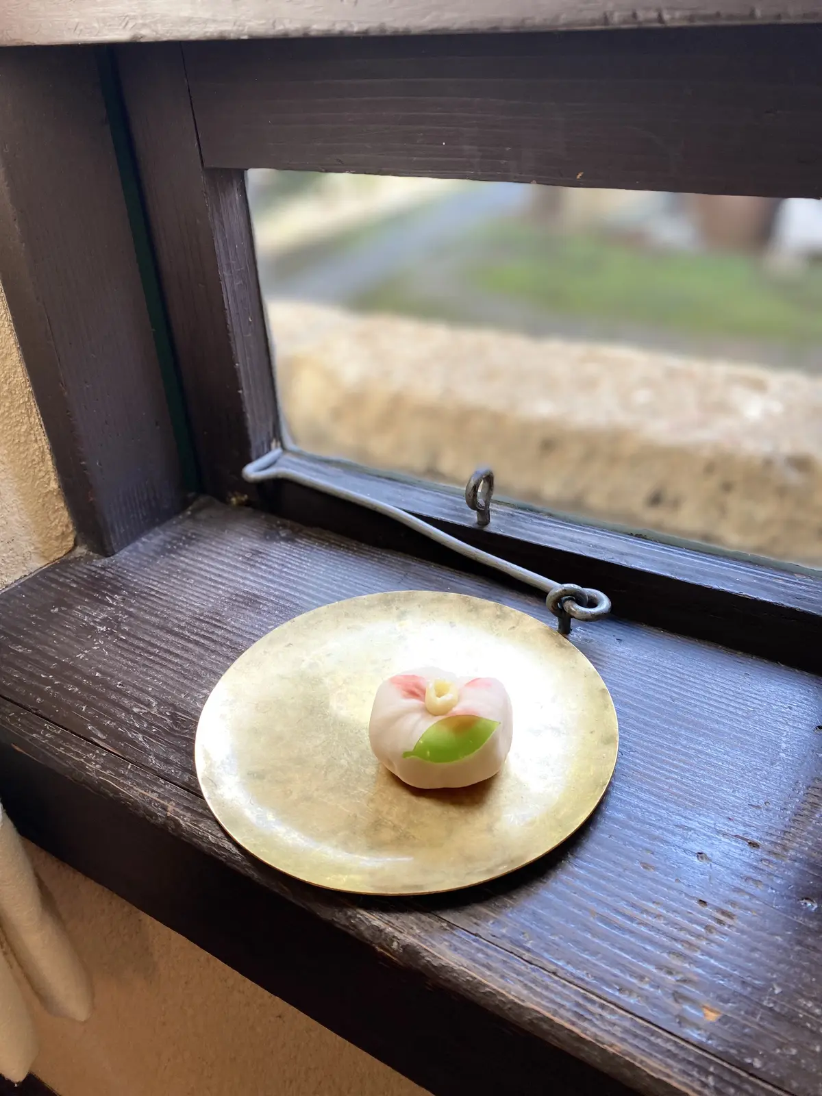 練り切り「曼荼羅」が窓辺の金皿に置かれたスタイリング写真。