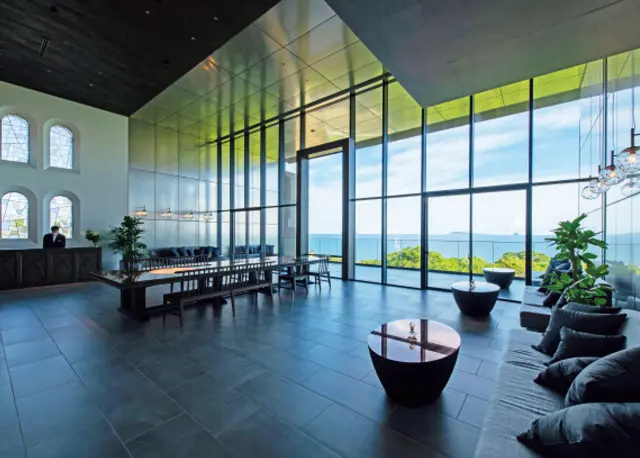 おだやかな光が射し込む吹き抜けのロビー。五島列島の教会建築からインスパイアされたモノトーンのステンドグラスが特徴